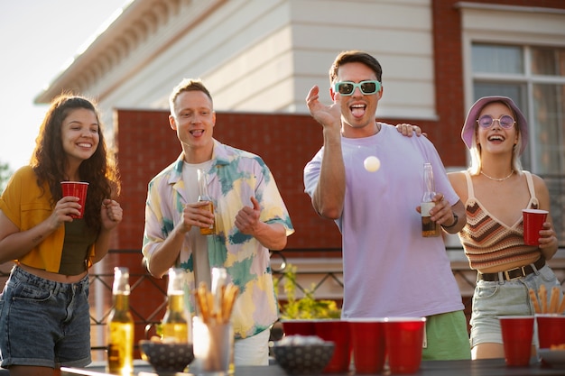 Free photo front view friends playing beer pong