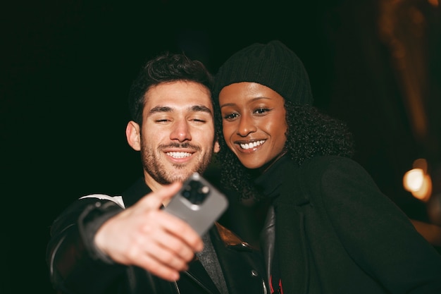 Front view friends taking selfie at night