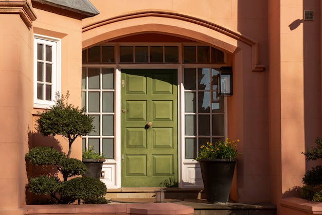 Free photo front view of front door with orange wall and plants