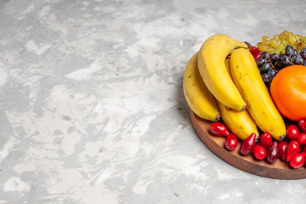 Front view fruit composition bananas dogwoods and grapes on light white background fruit berry freshness vitamine color