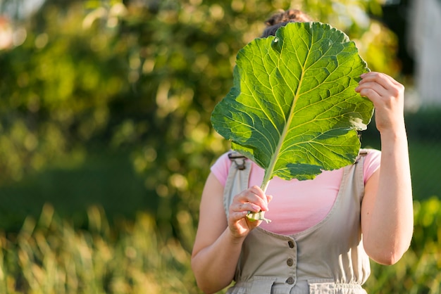 Free Photo front view girl holding lettuce leaf