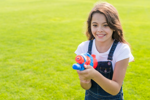 Front view girl holding a water gun