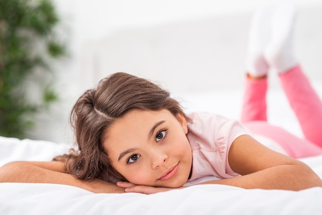 Front view girl at home laid in bed