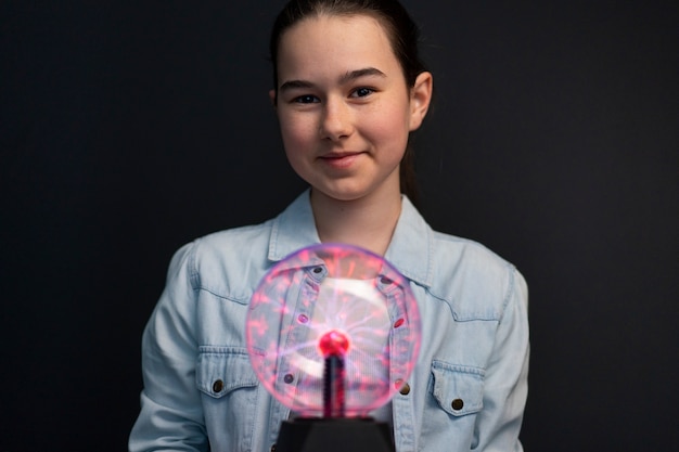 Front view girl interacting with a plasma ball