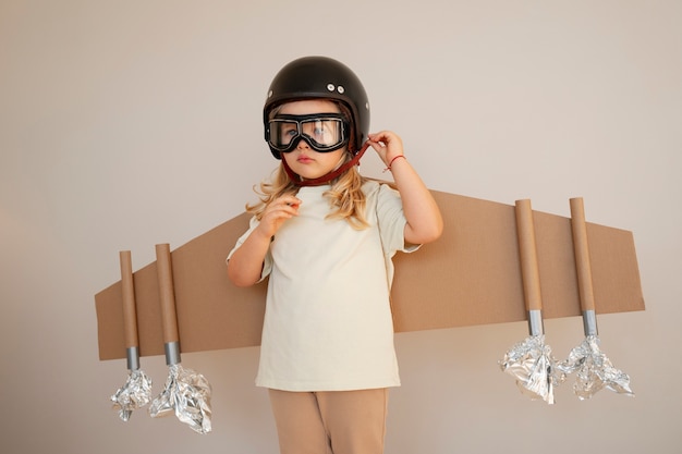 Front view girl playing with cardboard wings