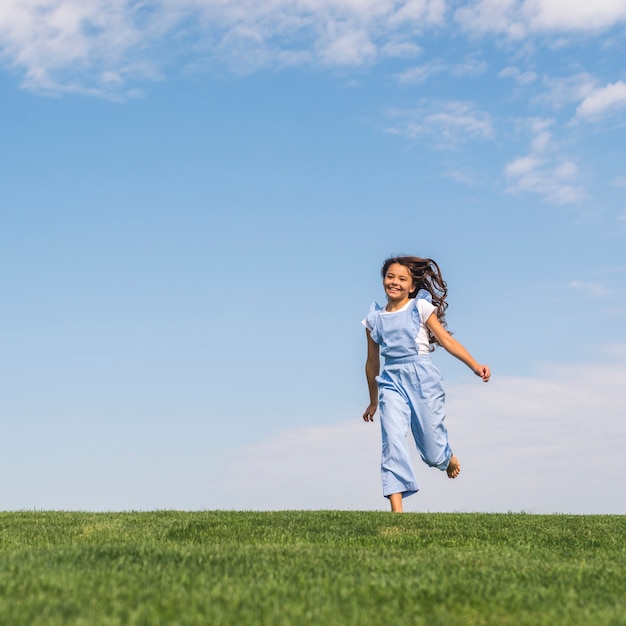 Front view girl running on grass