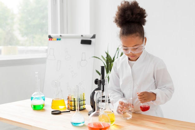 Front view of girl scientist experimenting with potions