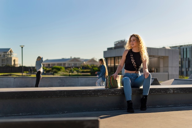 Front view girl sitting with skateboard