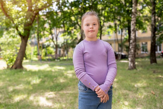 Front view girl with down syndrome outdoors