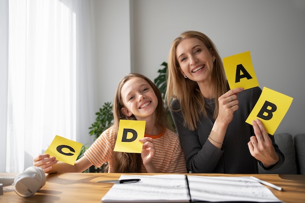 Free photo front view girl and woman holding cards