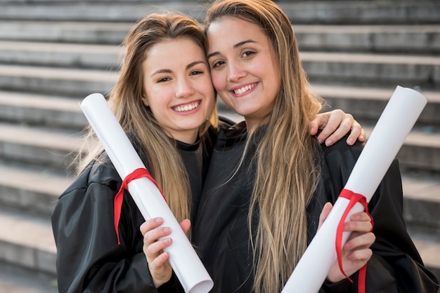 Free Photo front view girls holding their college certificates 