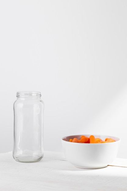 Free photo front view of glass jar with baby carrots for preserving