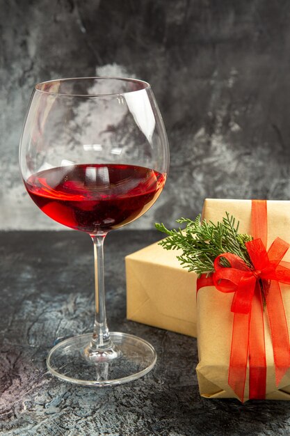 Front view glass of wine xmas gifts on dark background