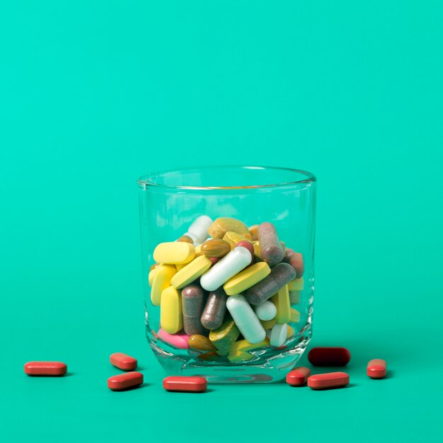 Front view of glass with assortment of pills