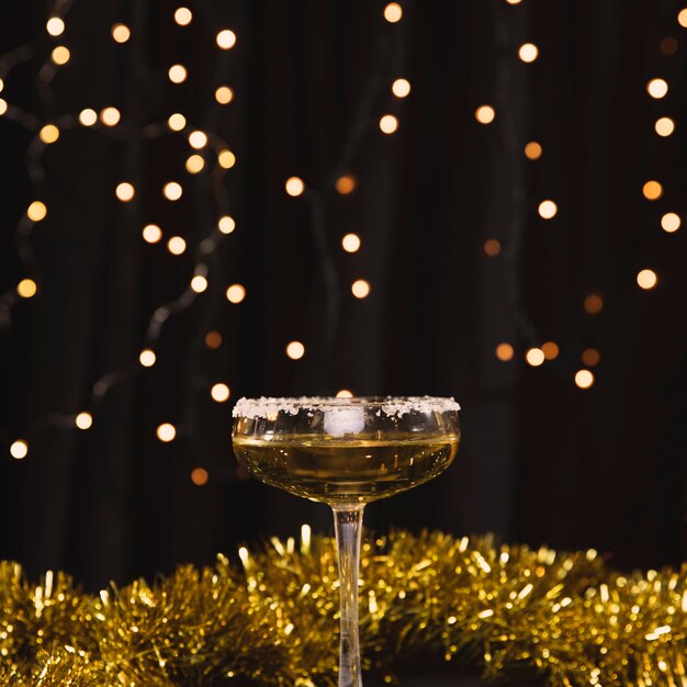 Front view glass with champagne and golden decorations