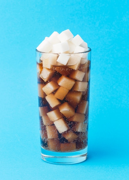 Free photo front view of glass with soft drink and sugar cubes