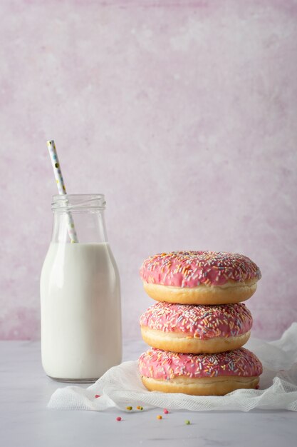 Front view of glazed doughnuts with sprinkled and milk bottle