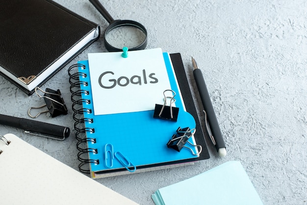 Free photo front view goals written note with notepad and pen on white background