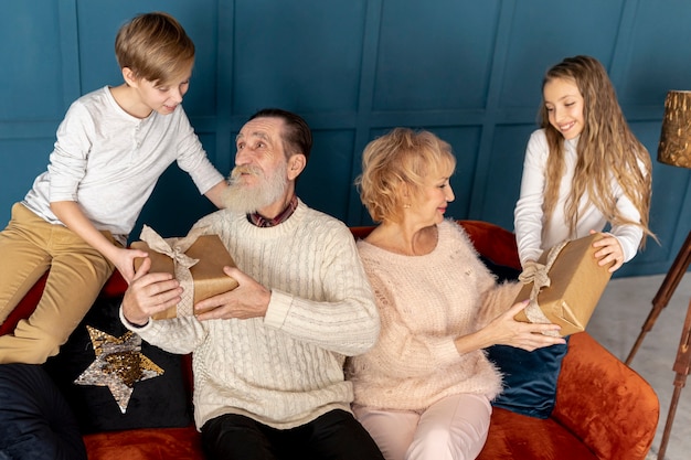 Free photo front view grandchildren giving their grandparents gifts