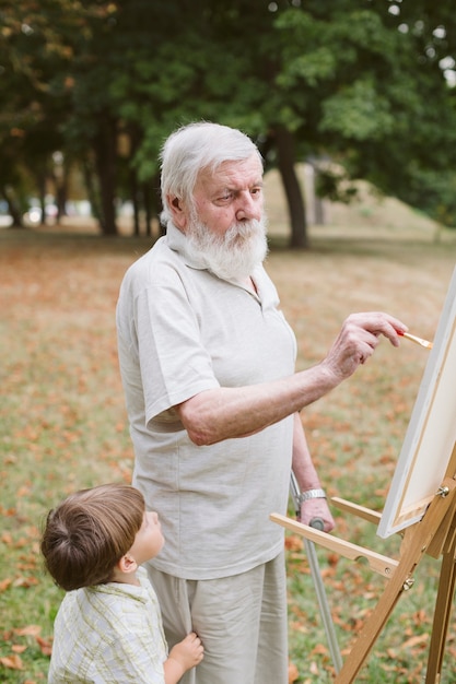 Front view grandson with grandpa painting