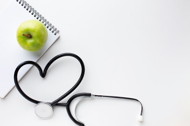 Free photo front view green apple and stethoscope