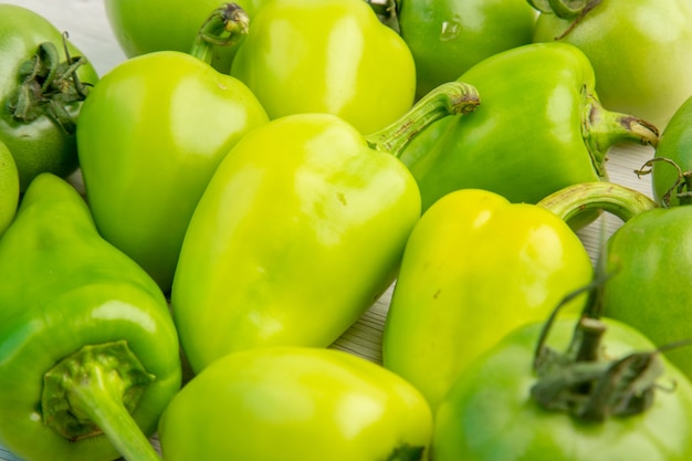 Free photo front view green bell- peppers with green tomatoes on white desk color ripe salad photo meal healthy life diet