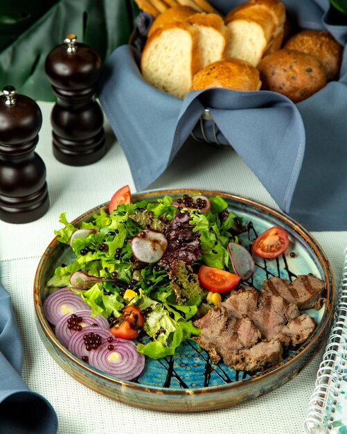 Front view grilled meat with vegetable salad and onions on a tray