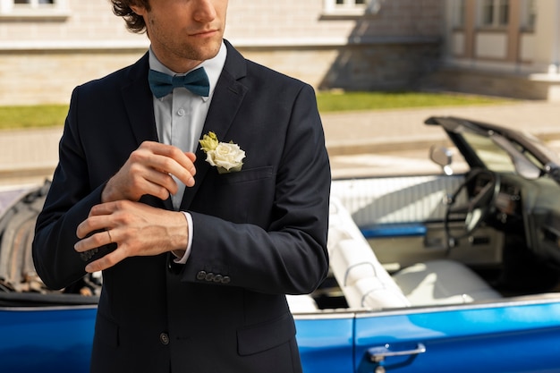 Front view groom standing near car