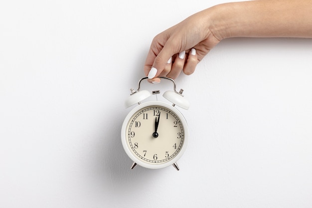 Free photo front view of hand held clock with copy space