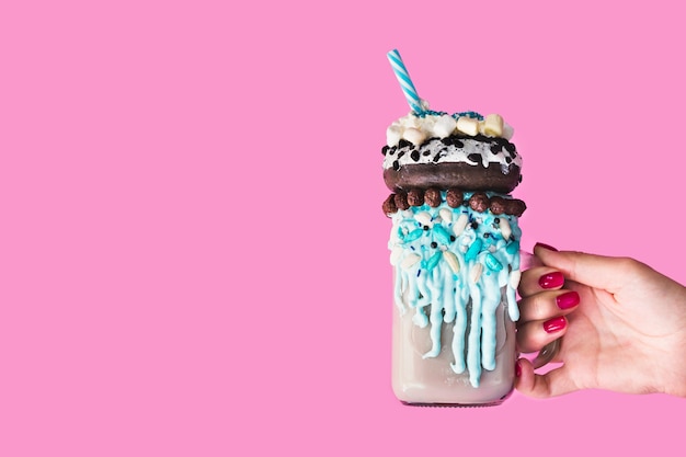 Free Photo front view of a hand holding a mug with milkshake