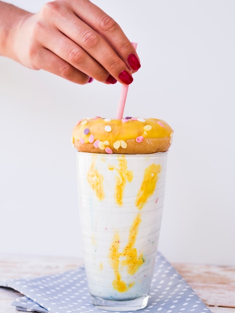 Free photo front view of hand and milkshake on wooden table