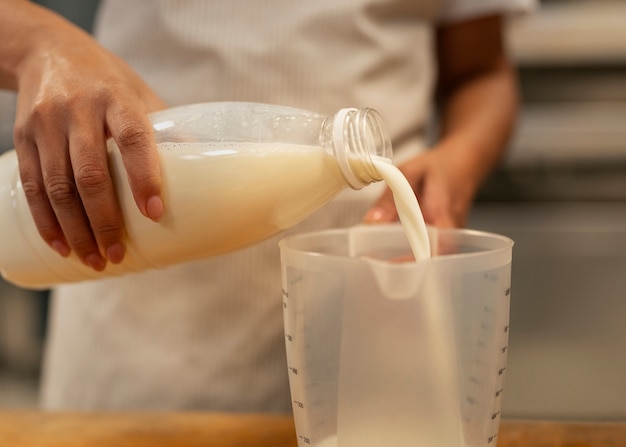 Free photo front view hand pouring milk in cup