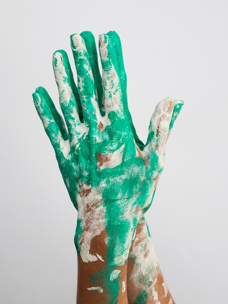 Free photo front view of hands covered in paint