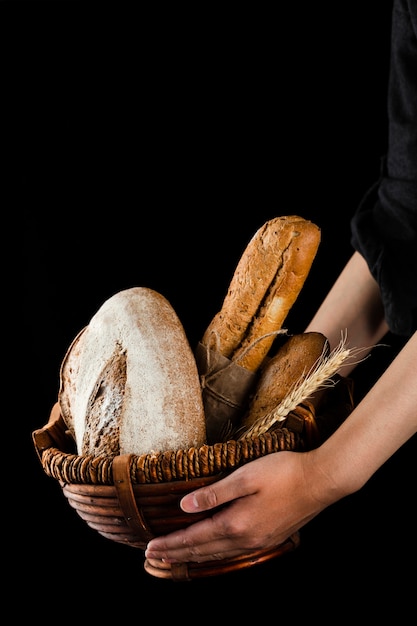 Free photo front view of hands holding a basket with bread