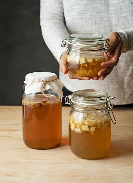 Front view hands holding kombucha jar