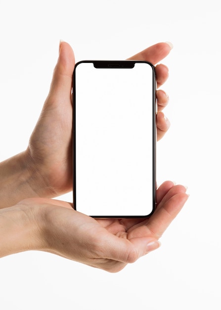 Free photo front view of hands holding smartphone with blank screen