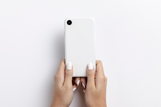 Free photo front view of hands holding smartphone