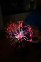 Free photo front view hands interacting  with a plasma ball