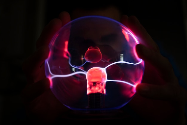 Free Photo front view hands interacting  with a plasma ball