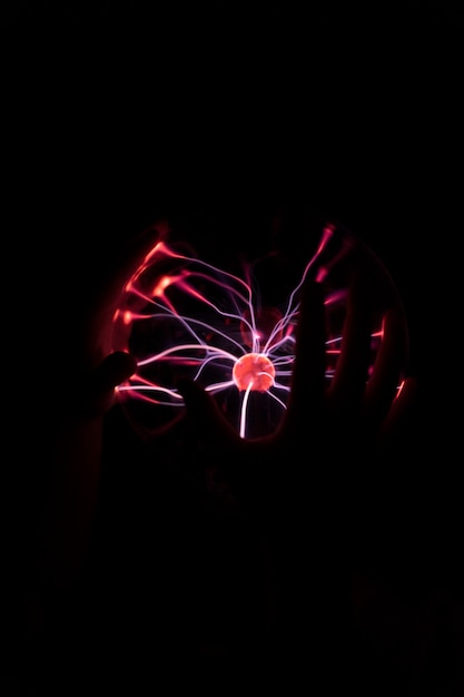 Free Photo front view hands interacting  with a plasma ball