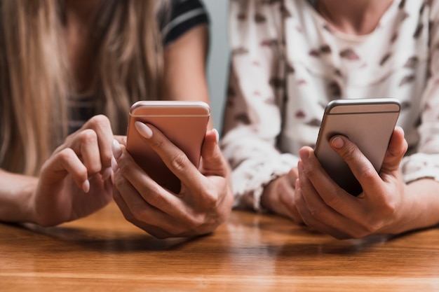 Front view hands typing messages on phones