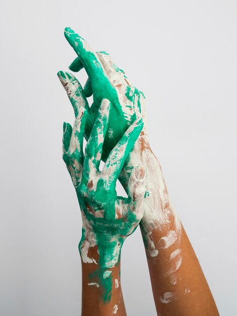 Free photo front view of hands with paint over them