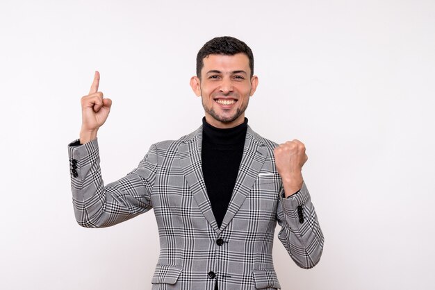 Front view handsome male in suit pointing at ceiling standing on white background