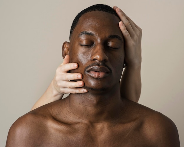 Free photo front view of handsome man posing with hands on his face