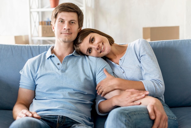 Front view of happy couple on couch while packing to move