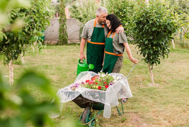 Free photo front view happy couple with wheelbarrow