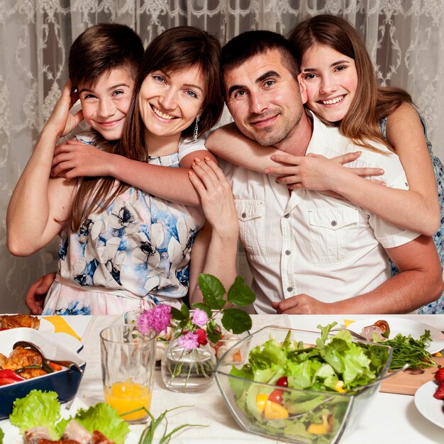 Front view of happy family posing at dinner table