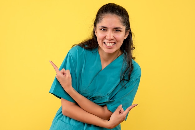 Free photo front view happy female doctor standing on yellow background