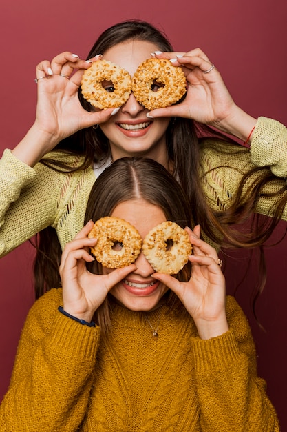 Free Photo front view happy girls with glazed doughnuts