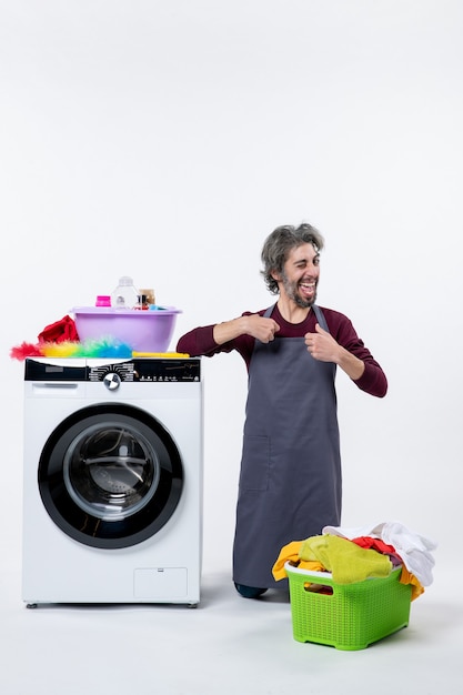 Front view happy housekeeper man standing on knee pointing at himself on white background